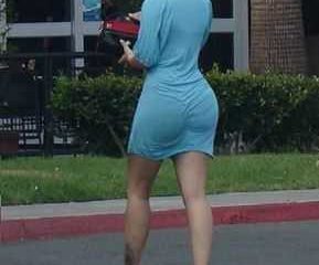 Mulher loira alta com vestido semi transparente azul