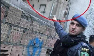 Policial pinta suas iniciais por cima do muro escrito FDN