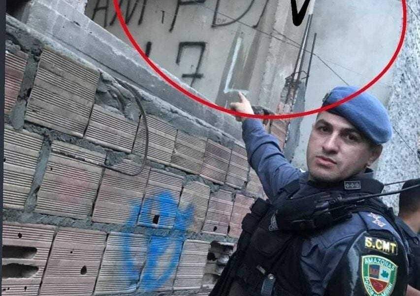 Policial pinta suas iniciais por cima do muro escrito FDN
