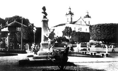 Monumento no jardim Jaú, sem o gradil. Ao fundo, o Pavilhão Universal (à esquerda) e a Catedral de Nossa Senhora da Conceição (à direita).