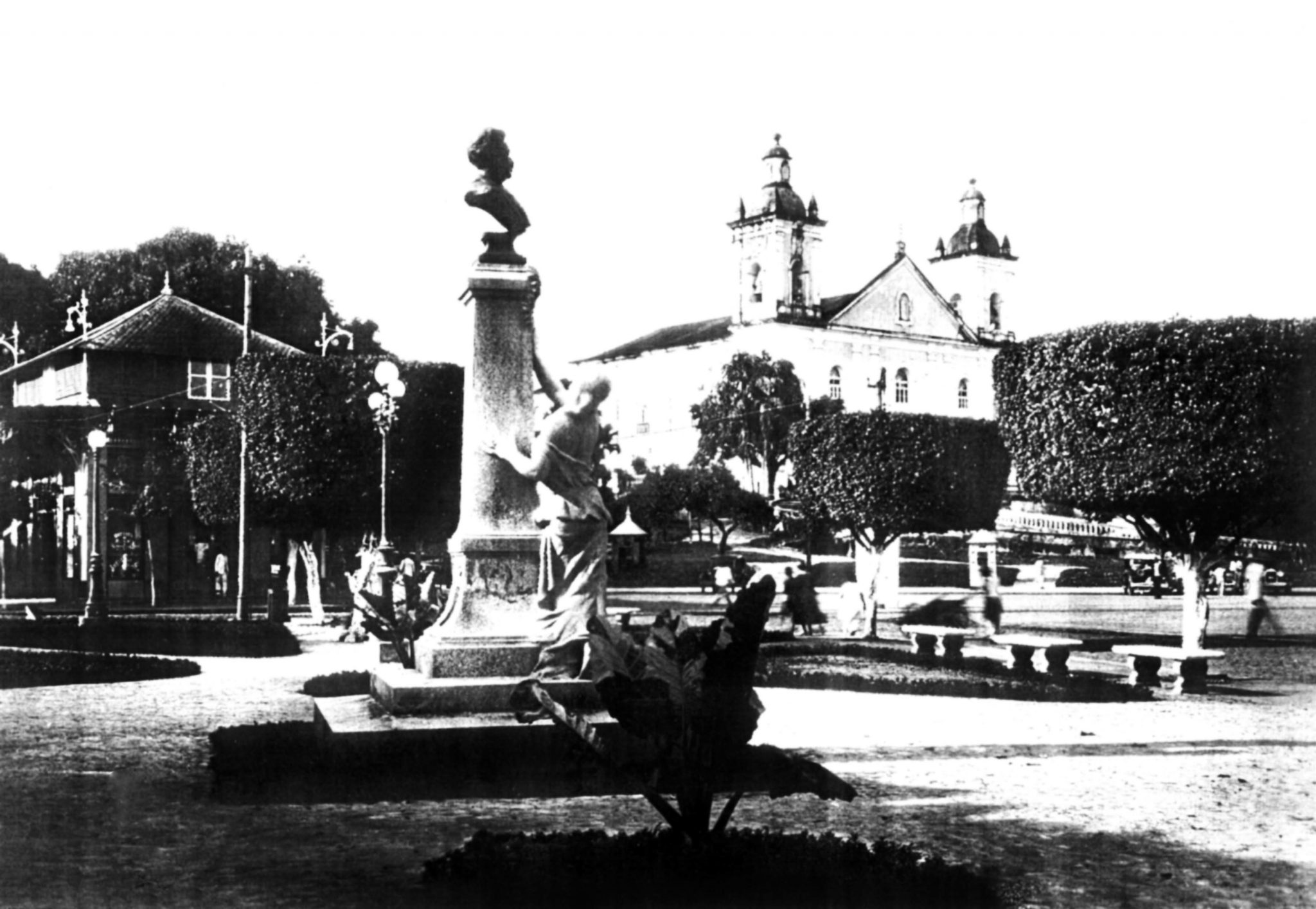 Monumento no jardim Jaú, sem o gradil. Ao fundo, o Pavilhão Universal (à esquerda) e a Catedral de Nossa Senhora da Conceição (à direita).